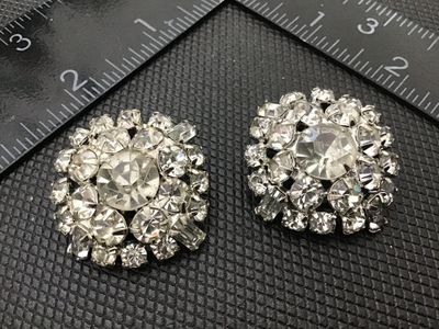 Sale Photo Thumbnail #91: Pair of vintage round cluster clip-on earrings featuring bright clear rhinestones in silver-tone prong settings. Each earring measures approximately 1 inch in diameter. Clip-on backs are functional. Good vintage condition with clear stones and minor age-a