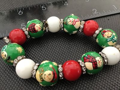 Sale Photo Thumbnail #13: Festive stretch bracelet featuring hand-painted style snowman beads, solid red and white accent beads, and rhinestone spacer rings. In good condition with light wear consistent with age and use.