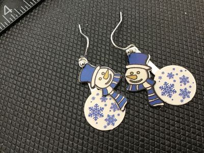 Sale Photo Thumbnail #183: Pair of festive winter drop/dangle earrings featuring snowmen wearing blue top hats and scarves alongside round snowflake charm pendants. Silver-tone French hook wire backs. Good pre-owned condition.