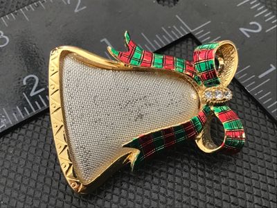 Sale Photo Thumbnail #35: Gold-tone Christmas bell brooch featuring a textured silver-tone center, green and red plaid enamel bow accent, and clear rhinestones. Pin back closure is functional. Measures approximately 2 inches wide. Shows minor signs of wear and light paint wear on 