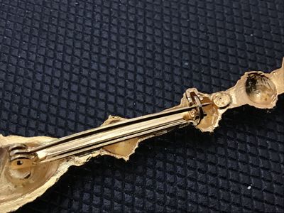 Sale Photo Thumbnail #63: A gold-tone costume jewelry brooch in the design of a royal scepter topped with a crowned cross. Features detailed textured metalwork and a standard rollover safety clasp on the reverse. Measures approximately 2.5 inches long. In good vintage condition wi