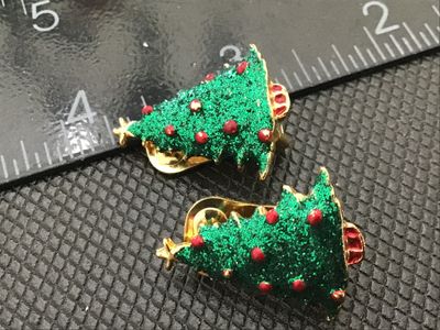 Sale Photo Thumbnail #48: Pair of gold-tone clip-on earrings shaped like decorated Christmas trees featuring green glitter enamel with raised red ornament dots and a gold star topper. Each earring measures approximately 1 inch in length. In good vintage condition with functioning 