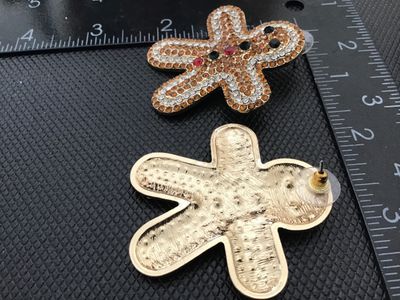 Sale Photo Thumbnail #40: Pair of festive holiday pierced post earrings shaped like gingerbread men, fully pave-set with amber, clear, red, and dark green/black rhinestones on a gold-tone metal backing. Each earring measures approximately 2 inches tall by 1.75 inches wide. Excelle