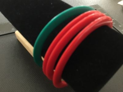 Sale Photo Thumbnail #156: Set of four lightweight plastic bangle bracelets, including three red and one green. Slim circular design. Measure approximately 2.5 to 3 inches in inner diameter. Good vintage condition with light surface wear.