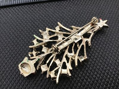 Sale Photo Thumbnail #47: A festive vintage gold-tone Christmas tree brooch pin featuring textured green enamel branches, a red base, and colorful multi-color rhinestone ornaments topped with a star. Measures approximately 2.25 inches long. Gold-tone back with a standard pin bar m
