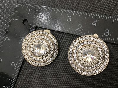 Sale Photo Thumbnail #134: Pair of vintage silver-tone clip-on earrings featuring concentric rings of sparkling pave rhinestones surrounding a central faceted rhinestone. Measures approximately 1.25 inches in diameter. Clip backs appear functional; light vintage wear consistent wit