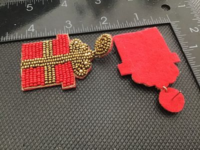 Sale Photo Thumbnail #176: Pair of festive Christmas present-shaped drop post earrings. Features red and gold seed bead embellishments on the front with a soft red felt backing. Measures approximately 2.5 inches in length. Good pre-owned condition with no visible missing beads or d