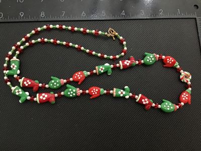 Sale Photo Thumbnail #76: A festive Christmas-themed beaded necklace featuring lampwork glass beads shaped like red and green mittens, holiday boots, and peppermints, interspersed with spacer beads. Measures approximately 28 to 30 inches long with a gold-tone toggle clasp. In good
