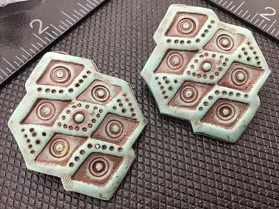 Sale Photo Thumbnail #89: Pair of vintage Southwestern style geometric pierced post earrings featuring a textured verdigris green finish over brown/copper metal accents. Geometric design with diamond and circle motifs. Measures approximately 1.5 inches. Good condition with light v