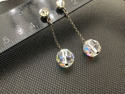Sale Photo Thumbnail #69: Pair of vintage clip-on/screw-back dangle earrings featuring faceted Aurora Borealis crystal glass bead drops attached by delicate link chains to rhinestone posts. The total length of each earring measures approximately 2 inches. Good vintage condition wi