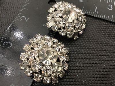 Sale Photo Thumbnail #93: Pair of vintage round cluster clip-on earrings featuring bright clear rhinestones in silver-tone prong settings. Each earring measures approximately 1 inch in diameter. Clip-on backs are functional. Good vintage condition with clear stones and minor age-a