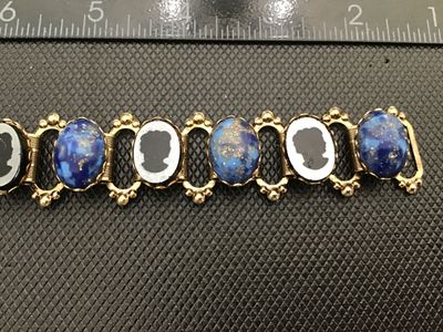 Sale Photo Thumbnail #2: Vintage gold-tone link bracelet featuring alternating oval faux lapis lazuli cabochons with flecks of gold and intaglio/cameo profile silhouette panels. Set in detailed gold-tone frames with beaded wire accents and a fold-over clasp. Measures approximatel