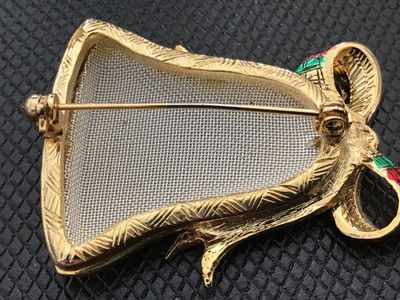 Sale Photo Thumbnail #34: Gold-tone Christmas bell brooch featuring a textured silver-tone center, green and red plaid enamel bow accent, and clear rhinestones. Pin back closure is functional. Measures approximately 2 inches wide. Shows minor signs of wear and light paint wear on 