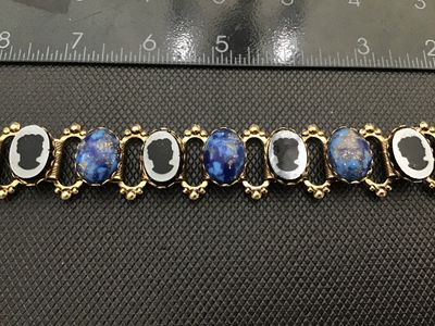 Sale Photo Thumbnail #3: Vintage gold-tone link bracelet featuring alternating oval faux lapis lazuli cabochons with flecks of gold and intaglio/cameo profile silhouette panels. Set in detailed gold-tone frames with beaded wire accents and a fold-over clasp. Measures approximatel