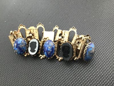 Sale Photo Thumbnail #5: Vintage gold-tone link bracelet featuring alternating oval faux lapis lazuli cabochons with flecks of gold and intaglio/cameo profile silhouette panels. Set in detailed gold-tone frames with beaded wire accents and a fold-over clasp. Measures approximatel