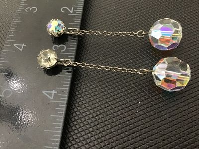 Sale Photo Thumbnail #70: Pair of vintage clip-on/screw-back dangle earrings featuring faceted Aurora Borealis crystal glass bead drops attached by delicate link chains to rhinestone posts. The total length of each earring measures approximately 2 inches. Good vintage condition wi