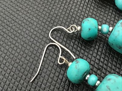 Sale Photo Thumbnail #23: A beaded costume jewelry set including a stretch bracelet and a pair of matching dangle/drop earrings. Features turquoise-colored composite beads, tiger's eye, jasper-like natural stones, and faceted glass accent beads. Earrings feature silver-tone fishho