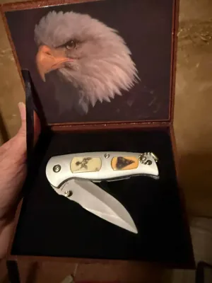 Sale Photo Thumbnail #2: Jaguar folding pocket knife featuring wildlife scrimshaw-style handle inlays, presented in an eagle-themed wooden display box.