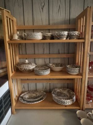 Sale Photo Thumbnail #35: A light wood folding bookcase displaying a set of brown transferware china dishes across three shelves.