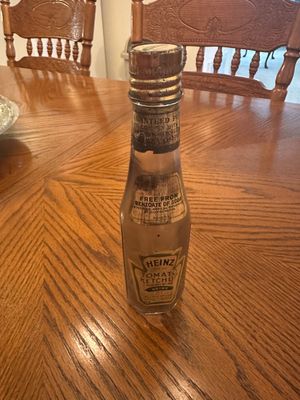 Sale Photo Thumbnail #65: Vintage early-to-mid 20th-century glass Heinz Tomato Ketchup bottle with original labels and screw cap, showing age-related wear.
