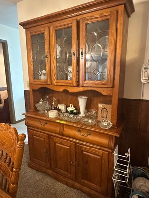 Sale Photo Thumbnail #68: Traditional oak china cabinet with leaded glass door panels, lower drawers, and cabinet storage, displayed with assorted glassware.