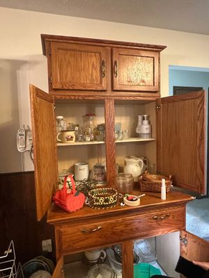 Sale Photo Thumbnail #67: Traditional oak hutch cabinet filled with various kitchenware, small baskets, and decorative home items.