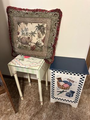 Sale Photo Thumbnail #6: Hand-painted drop-leaf accent table topped with a safari-patterned fringed tapestry pillow, positioned beside a laundry-themed storage cabinet.