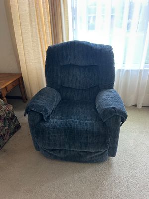 Sale Photo Thumbnail #21: Plush navy blue fabric reclining armchair with padded armrests, shown in good condition.