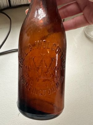 Sale Photo Thumbnail #61: Vintage brown amber glass bottle from The L.A. Wolcott Co. with embossed lettering and trade mark logo.