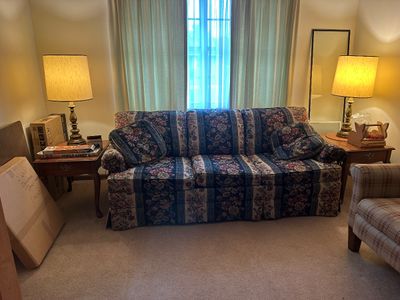 Sale Photo Thumbnail #36: Three-cushion floral tapestry sofa flanked by matching brass table lamps and wooden end tables.