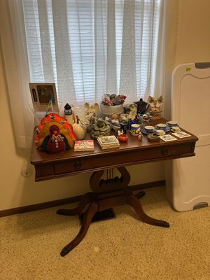 Sale Photo Thumbnail #17: Traditional mahogany lyre base console table displaying an assortment of home decor, including tea sets, seasonal decorations, figurines, and coasters.