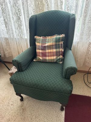 Sale Photo Thumbnail #30: Traditional green diamond-patterned upholstered wingback chair with cabriole front legs, styled with a fringed plaid accent pillow.
