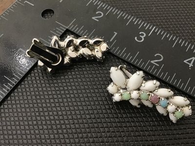 Sale Photo Thumbnail #48: Pair of vintage silver-tone clip-on earrings featuring white milk glass navette cabochons accented with small pastel-colored round cabochons/rhinestones (pink, green, and blue). Silver-tone metal backing with clip-on mechanisms in working order. Each earr