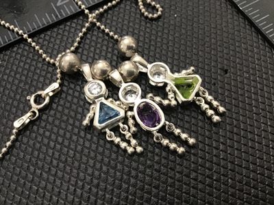 Sale Photo Thumbnail #68: Sterling silver ball chain necklace featuring three charming stick-figure girl pendants, each set with a clear top stone and colored gemstone bodies (blue, purple, and green). Stamped 925 on the chain clasp and pendant bails. 
925 Pendants 
- Material: St