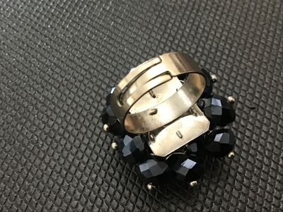 Sale Photo Thumbnail #124: Vintage statement cluster ring featuring faceted black glass beads secured with headpins onto a base metal structure. Features an adjustable band. Shows minor age-appropriate wear and light patina on the metal finish. In good overall condition with all be