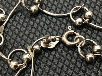 Sale Photo Thumbnail #94: A sterling silver link chain necklace featuring curved bar links accented with small bead charms. Stamped 925 near the spring ring clasp. Measures approximately 18 inches in total length when laid end to end. In good pre-owned condition with light tarnish
