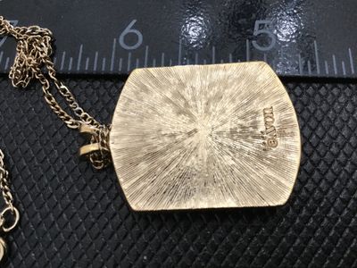 Sale Photo Thumbnail #52: Vintage Avon gold-tone necklace featuring a rectangular pendant with a raised ceramic or porcelain inset depicting pink roses with green leaves. Marked '© AVON' on the textured reverse side. Includes a gold-tone fine link chain with a spring-ring clasp. 