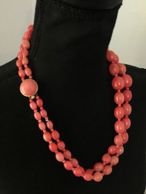 Sale Photo Thumbnail #223: A vintage double-strand beaded necklace featuring salmon pink molded plastic oval and round beads with smaller spacer beads. Includes a gold-tone push-in box clasp with a matching cabochon accent, marked 'HONG KONG' on the reverse. In good vintage conditi