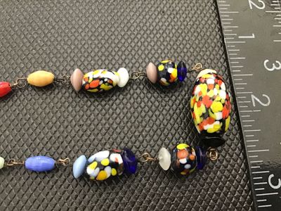 Sale Photo Thumbnail #45: A vintage colorful glass bead necklace featuring a mix of speckled multi-color 'end of day' style Murano glass beads along with wire-wrapped solid-colored glass accent beads. The necklace measures approximately 18 inches in total length and is finished wi