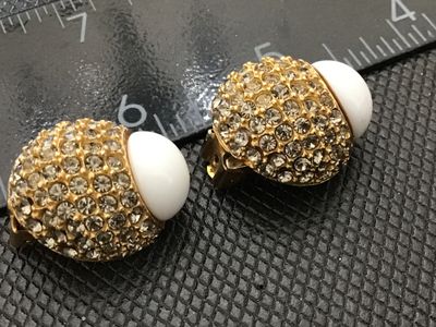 Sale Photo Thumbnail #40: Pair of designer vintage Blair Delmonico clip-on earrings. Features a textured gold-tone setting pave-set with sparkling clear rhinestones, accented with a smooth white cabochon top. Both clips are signed 'Blair Delmonico' on the back plaque. Good pre-own