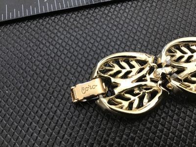 Sale Photo Thumbnail #18: A vintage Coro gold-tone costume jewelry panel link bracelet featuring openwork leaf motif design with textured and polished details. Signed 'Coro' on the fold-over clasp closure. Measures approximately 7 inches in length. In good vintage condition with m