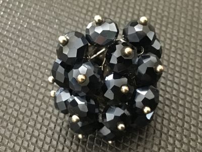 Sale Photo Thumbnail #123: Vintage statement cluster ring featuring faceted black glass beads secured with headpins onto a base metal structure. Features an adjustable band. Shows minor age-appropriate wear and light patina on the metal finish. In good overall condition with all be