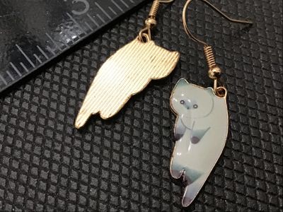 Sale Photo Thumbnail #210: Pair of gold-tone dangle fishhook earrings featuring enamelled white and dark point Siamese cat charms. Good condition with light surface wear.