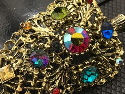 Sale Photo Thumbnail #130: A vintage gold-tone filigree Christmas tree brooch pin by DODDZ. It features multi-colored rhinestones and aurora borealis accents in various cuts and settings. Signed ©DODDZ on the reverse with a rollover pin clasp. Measures approximately 2.5 inches in 