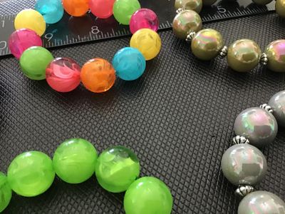Sale Photo Thumbnail #12: Lot of 5 beaded stretch bracelets featuring oversized round beads in various colors, including pearlescent pink, iridescent olive green, iridescent gray, bright green, and a multi-color marbled style. Most bracelets include small decorative silver-tone sp