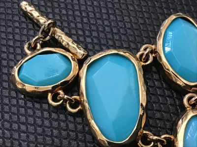 Sale Photo Thumbnail #200: Bold gold-tone link statement bracelet featuring textured, hammered-style bezel settings with bright turquoise-colored cabochons and faceted stones. Features a textured toggle closure. In good pre-owned condition with no  minor wear to the finish.