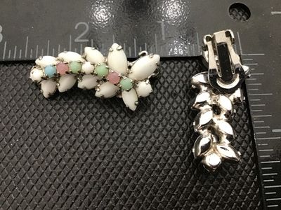 Sale Photo Thumbnail #50: Pair of vintage silver-tone clip-on earrings featuring white milk glass navette cabochons accented with small pastel-colored round cabochons/rhinestones (pink, green, and blue). Silver-tone metal backing with clip-on mechanisms in working order. Each earr