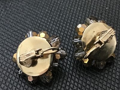Sale Photo Thumbnail #126: Pair of vintage cluster clip-on earrings featuring faceted champagne and smoky crystal beads wire-wrapped onto gold-tone bases. Each earring measures approximately 1 inch in diameter. In good vintage condition with functioning clip backs.