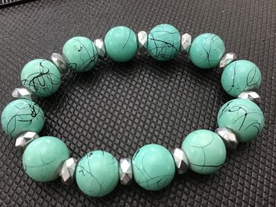 Sale Photo Thumbnail #172: Turquoise-colored round beaded stretch bracelet featuring dark veining/marbling details and faceted silver-tone spacer beads. Lightly used condition with no visible damage.