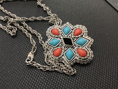 Sale Photo Thumbnail #228: A vintage Avon silver-tone convertible pendant brooch necklace featuring a Southwestern style starburst medallion set with faux turquoise, coral-colored, and black resin stones. The versatile piece functions as both a pendant on a twisted rope chain and a